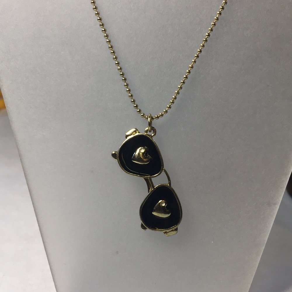 Betsey Johnson sunglasses with heart pendant on small gold long bathroom chain.